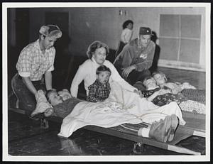 [illegible] Down--Mr. and Mrs. Smith [illegible]dren for bed in school gym at Lynn after leaving heatless home. From left, Arthur, 16, Carole, 12, Richard, 2, Cynthia, 9, and Joyce, 14.