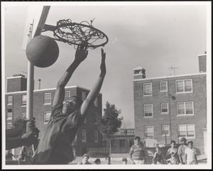 Boy slam dunking on basketball court