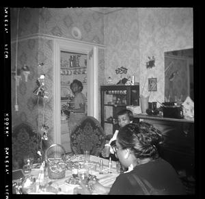 Yvonne stands in doorway, Vivian and another woman seated at the table