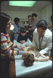 Spanish-speaking doctor examining child at Boston community clinic