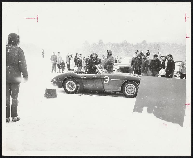 Despite seventeen degree temperature and steady snowfall hardy sports car drivers participated in a rally on the bleak icy runway of the North Newport, New Hampshire Airport. Here a driver checks in with officials at the finish line. All drivers are clocked and cars leave one at a time.