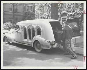 Moving Day for Harvard students bring out hearses for use in transporting personal belongings from the dormitories. Students use hearses to sleep in while on skiing weekends in the winter. Shown here are Ralph Vogel of Milwaukee, Wis., the driver, and Jerry Hemminger, Fairlawn, N. J. (left), and Jack Sands of Skaneateles, N. Y.