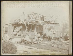 Oak Lawn, Ill: Two male members of a household here 4/22 seem to be thinking “what do we do now?” as they sit dejectedly on the steps of their wrecked home. The wife and mother were injured and is in good condition in hospital. This scene is more or less typical of the misery and destruction that followed in wake of the destruction wrought when the tornado roared through the area 4/21. The death toll is rising as workers find more bodies in trouble.