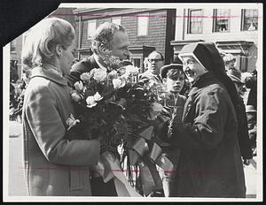 First Lady Mrs. Kathryn White, presents her parade floral bouquet to Nun while marching with her husband in St. Patrick's Day festivities.