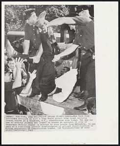 Police Unload Picket Cargo-- New York City policemen struggle to lift a limp Negro picket from truck carrying cement blocks at a Brooklyn, N.Y., construction site today. The man was one of several pickets who jumped on trucks at entrance to site of Downstate Medical Center in attempt to stop trucks from unloading, It was part of a continuing protest demonstration of alleged discrimination in hiring procedures in construction trades.