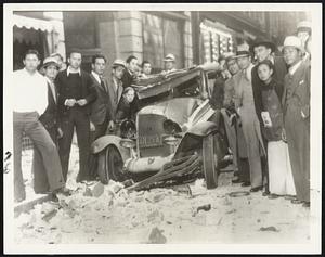 An automobile badly damaged by falling bricks from the roof of the Southeast building, formerly occupied by the Los Angeles Chamber of Commerce. This picture was taken just after the first severe shock in Los Angeles.