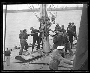 A group of men working on the rigging of a sailing ship