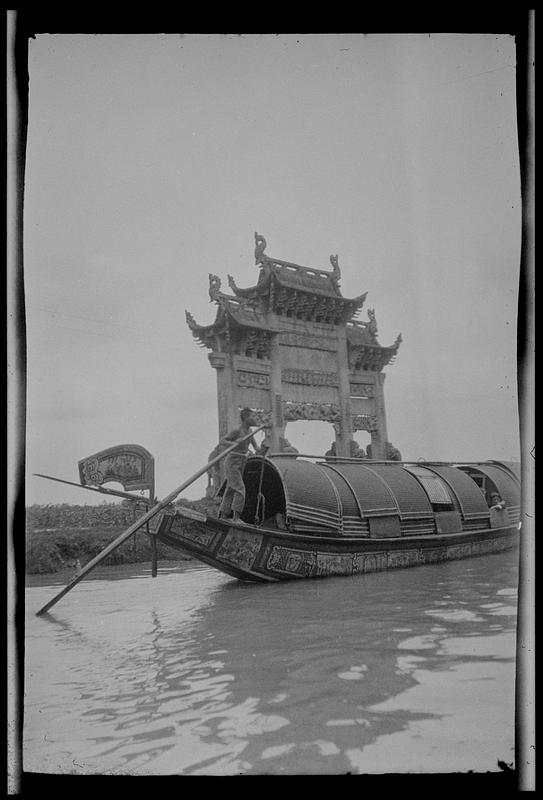 Sampan on canal in front of decorative gate