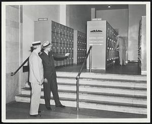 Here's the latest in checking... at Grand Central -- J. H. Hustis, Jr., Manager of Grand Central Terminal, New York looks over the brand new stramlined parcel checking locker room which has replaced the old East Luggage Room at Grand Central. With him is Frank Smith, New York District Manager for the American Locker Company. Mr. Hustis stated that since installation a constant stream of travelers has checked luggage in these new lockers. This new installation is one of many at Grand Central Terminal where, Mr. Hustis stated, there are already over 1800 parcel checking lockers, and when the program is completed, there will be practically 3000. The trend to lockers throughout the United States has been growing at a rapid rate since early war days, and Grand Central Terminal is only one of scores of places in the greater New York area where this modern method of parcel checking is available. In fact, there are over 2000 installations of parcel checking lockers throughout the country, and today they are to be found not only in rail and bus stations from coast to coast, but also in airports, department stores, theaters and other recreation centers.[paragraph break] Wartime travel conditions casued this habit of checking in lockers to spread rapidly. Millions of servicemen and women found that a few hours between trains could be much better enjoyed without toting heavy gear along. And the trend in peacetime may well be seen when, as Mr. Smith points out, people checked in lockers more than 50 million times throughout the country the past year.