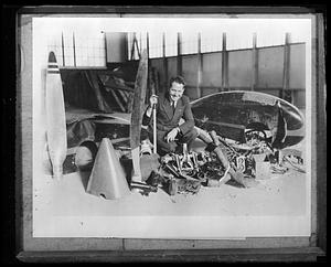 Jimmie Mattern posing with broken parts of an airplane