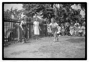 Two young women playing horseshoes