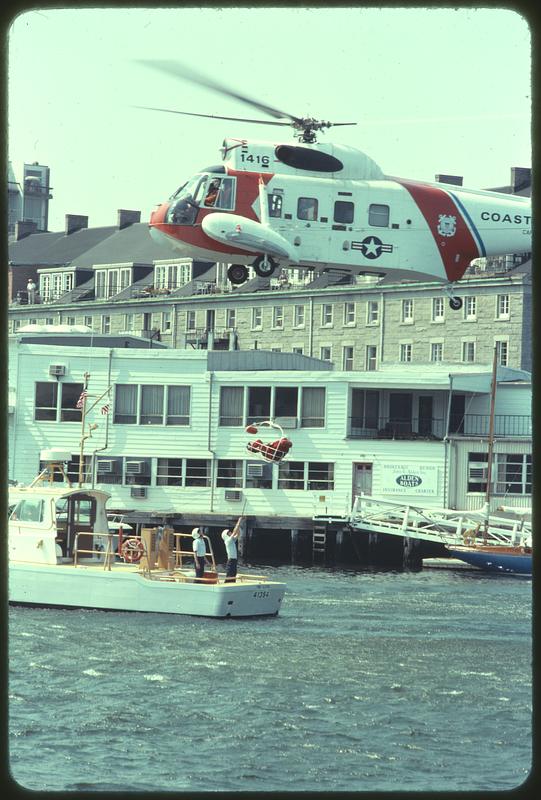 Coast Guard helicopter lifting man off Coast Guard boat, Boston Harbor