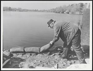 Raymond Benoit put sandbag in place at Morey's Dam