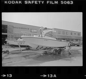 Two people washing boat near Hudson's