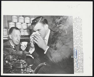 Moose’s Cup of Tea -- Steam from a kettle swirls around Bill (Moose) Skowron as the New York Yankee first baseman sips a cup of tea to help launch annual meeting of U.S. board of tea experts at Food & Drug Administration office today. At left is Thomas Moss of San Francisco, one of the official tea testers. Seven experts took part in the annual industry-government operation sampling imported teas to establish standards by which all teas will be graded after May 1.