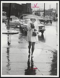 Janet Gaffney carries her shoes on Cambridge street after being let out early from work in the Government Center. She was heading for a dry change at her Charles street apartment.