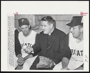 Now in My Day -- Bishop John Wright of the Pittsburgh Roman Catholic Diocese shows Pitcher Paul Geil (l) of the Pittsburgh Pirates how he used to grip a fast ball in his day. The scene took place today in the Pirate dugout before Pittsburgh walloped the Cincinnati Reds 13-0. Pirate hurler Joe Gibbon (r) looks on.