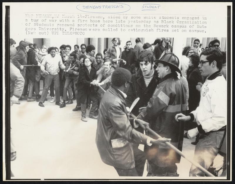 Fireman, aided by some white students engaged in a tug of war with a fire hose here late yesterday as Black Organization of Students renewed protests of conditions on the Newark campus of Rutgers University. Fireman were called to extinguish fires set in campus.