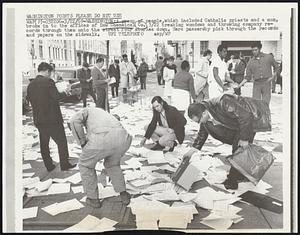 A group of people, which included Catholic priests and a nun, broke in to the offices of Dow Chemical Co. 3/22 breaking windows and throwing company records through them onto the street four stories down. Here passersby pick through the records and papers on the sidewalk.