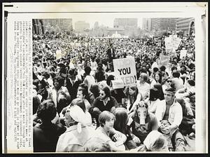 Students Mass at Independence Hall - Crowd estimated at more than 12,000 students and other protestors mass at Philadelphia's Independence Hall Mall Friday after a march through city streets in protest against United States involvement in Southeast Asia. Youth in center foreground wears gas mask as he sits in front of a sign which reads "Nixon, You Lied."