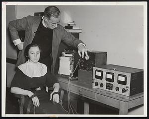 Uses Lie Detector in Effort to Clear Brother Father Walter G. Summers of the Fordham University Experimental Psychology Laboratory in the Woolworth Building at the controls of a lie detector as Miss Helen Keller submits to a test. John J. Anthony of the WMCA Good Will Hour arranged the test to help her in her efforts to clear her brother who has been sentenced to from 30 to 60 years on a charge of robbery.