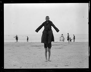 Two people in a trench coat on a beach
