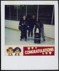 Group of four helping each other ice skate