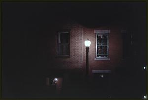Street lamp by brick wall at night