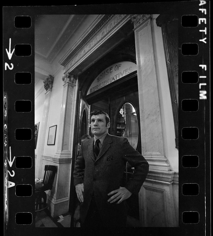 Man standing in front of the entryway to the House of Representatives chamber of the Massachusetts State House