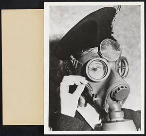 Gas Masks As A Handbag. Geneva- A novel gas mask developed by a Switzerland manufacturer which includes make-up equipment, handbag essentials. The young woman holds the lipstick, and the powderbox and mirrors are attached between the eye glasses.
