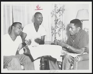 Marking Time while waiting for the clearing skies that didn't come, Earl Battey, Al Smith and Harry Simpson (left to right), members of the Chicago White Sox, try their hands at knock rummy.