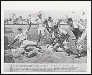 Sliding Practice for the Cardinals- The St. Louis Cardinals use this sand pit to conduct their sliding sessions in a safe way. Alex Grammas is taking his turn with coach Red Schoendienst as instructor. From left are Grammas; Gene Oliver; Ray Bond; Bob Duliba; Red Schoendienst and Johnny Kucks.