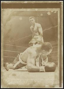 Clay Knock Out Folley--Champion Clay stands over Zora Folley after he knocked out the challenger in 7th round of their heavyweight title right in New York's Madison Square Garden tonight. Clay retained his title with the knockout in 1:48 of the round.
