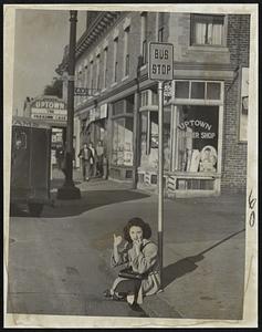 Hoping For A Lift – Using a bus stop sign post as a back rest, Miss Madeline Reppucci of Edwards court, Lynn, sits on a curb on Western avenue waiting for anything with wheels.