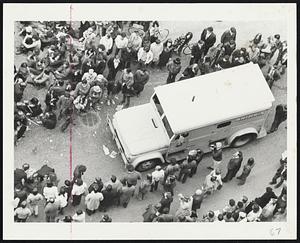 Brinks truck inches its way through street demonstrators at Gov center.