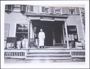 H. E. Roote standing in front of his store