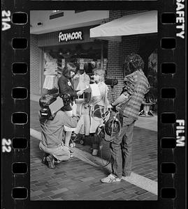 Market researcher interviews customers at shopping mall in Brighton