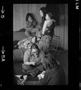 Two women play cards, women and children in background, Alaska