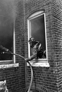 Firefighter Tom Lassiter passing a line through the window