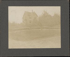 Photograph of a house with a driveway in the foreground