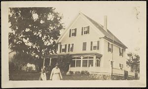 Two women in front of house