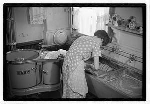A woman doing laundry at a sink