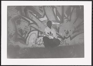 Boy sitting in front of a mural in the Teen Program Room