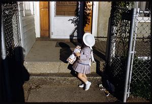 Girl holding package of Wonder Bread by house entrance