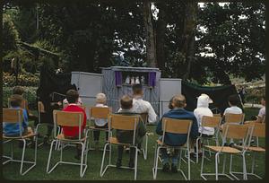 Children watching outdoor puppet show, British Columbia