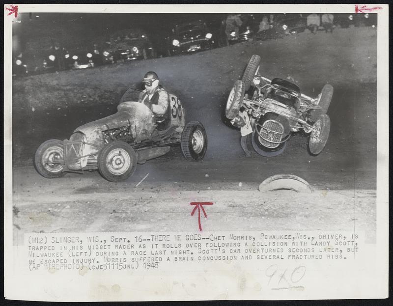 There He Goes -- Chet Morris, Pewaukee, Wis., driver, is trapped in his midget racer as it rolls over following a collision with Landy Scott, Milwaukee (left) during a race last night. Scott’s car overturned seconds later, but he escaped injury. Morris suffered a brain concussion and several fractured ribs.