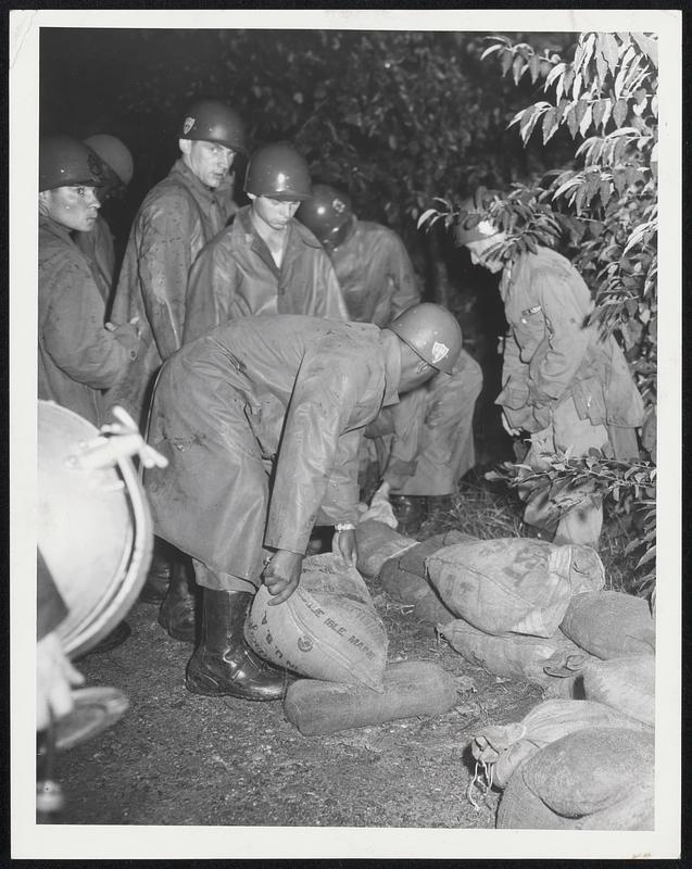 Army Helps place sandbags along Arlington Heights Reservoir sluiceway. About 150 town employes, Boy Scouts and other volunteers assisted in preventing a possible rupture threatening hundreds of homes.