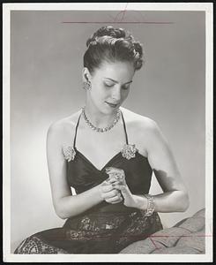 Diamond Glitter in sophisticated splendor when worn by new screen star Valli. The set, worth a half million dollars and weighing over 300 carats, includes large flower clips whose petals open and close, ear-clips of the same motif, a circular necklace of evenly matched stones, a sumptuous emerald-cut ring and a link bracelet.