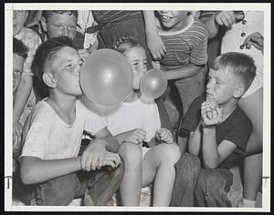 Quick, Henry, the Blow-Out Patches!-Joseph Meighan, 11, shows the crowd how it is done in winning Boston park department's bubble gum contest at Mary Hemingway playground, Dorchester. Mary Gibbs, 6, took second prize with astoning lung capacity.
