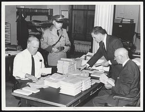 Sorting Official Returns, Secretary of State Kevin H. White, works on Sunday with Election Commission officials gathering tallies for official count. Left to right, John McDonnell Det. Sgt. Manuel S. White, Jr., State Police assigned to guard sheets, Sec. White and William S. Sullivan, supervisor, Division of Elections. Official counting may start Wednesday morning.